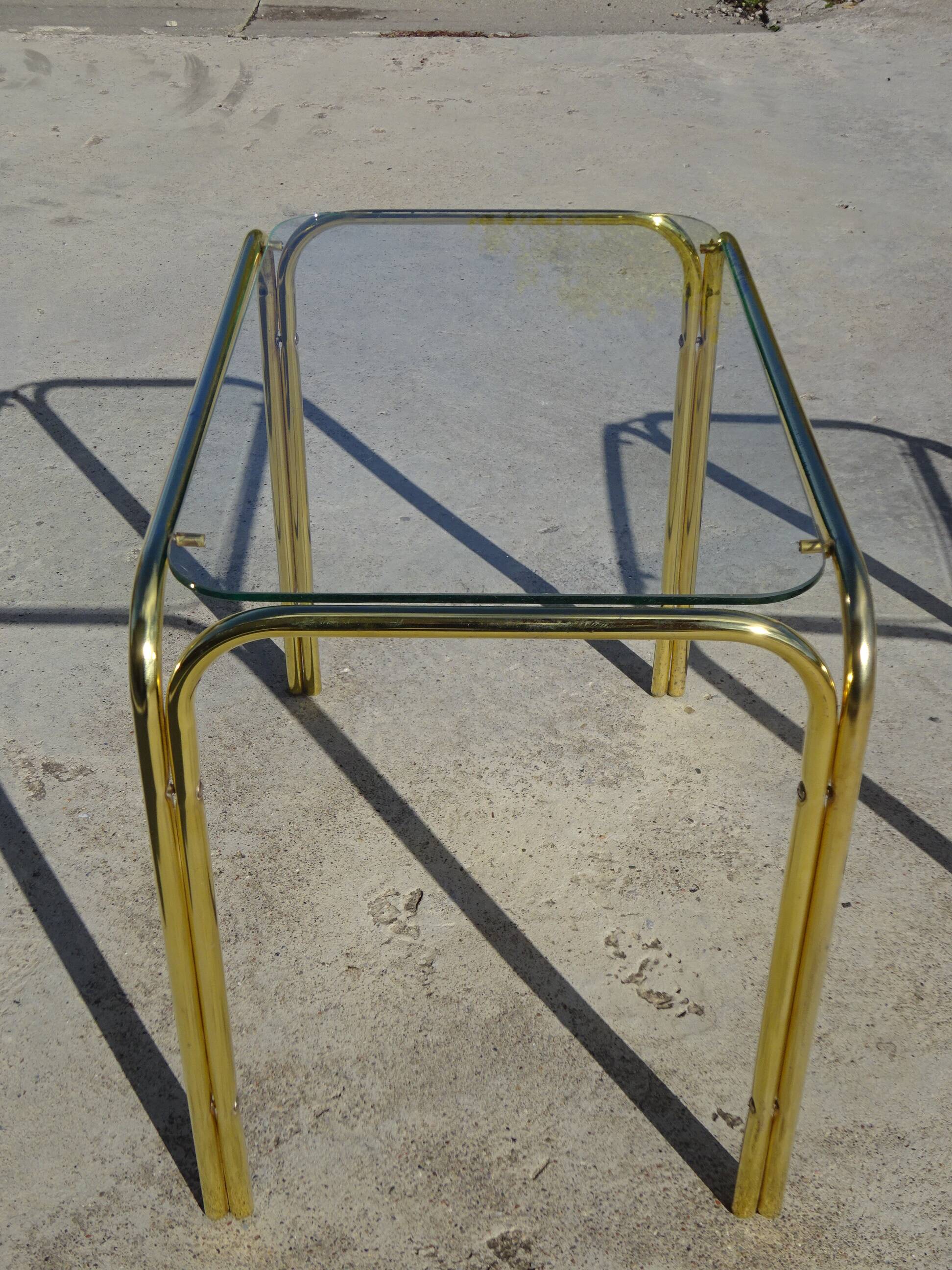 Nested tubular tables in gold metal.