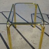Nested tubular tables in gold metal.