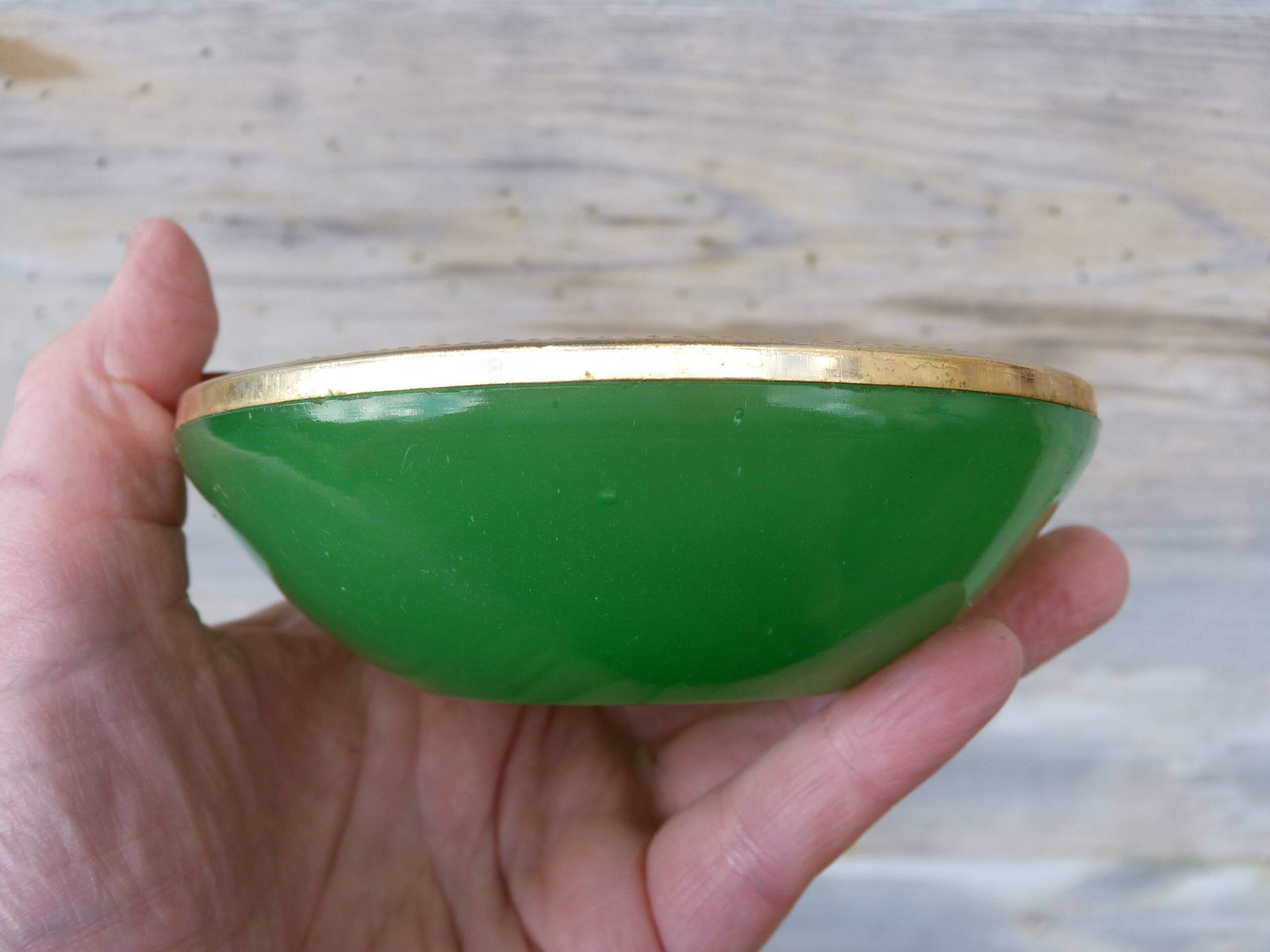 Green glass ashtray set in gold brass