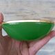 Green glass ashtray set in gold brass