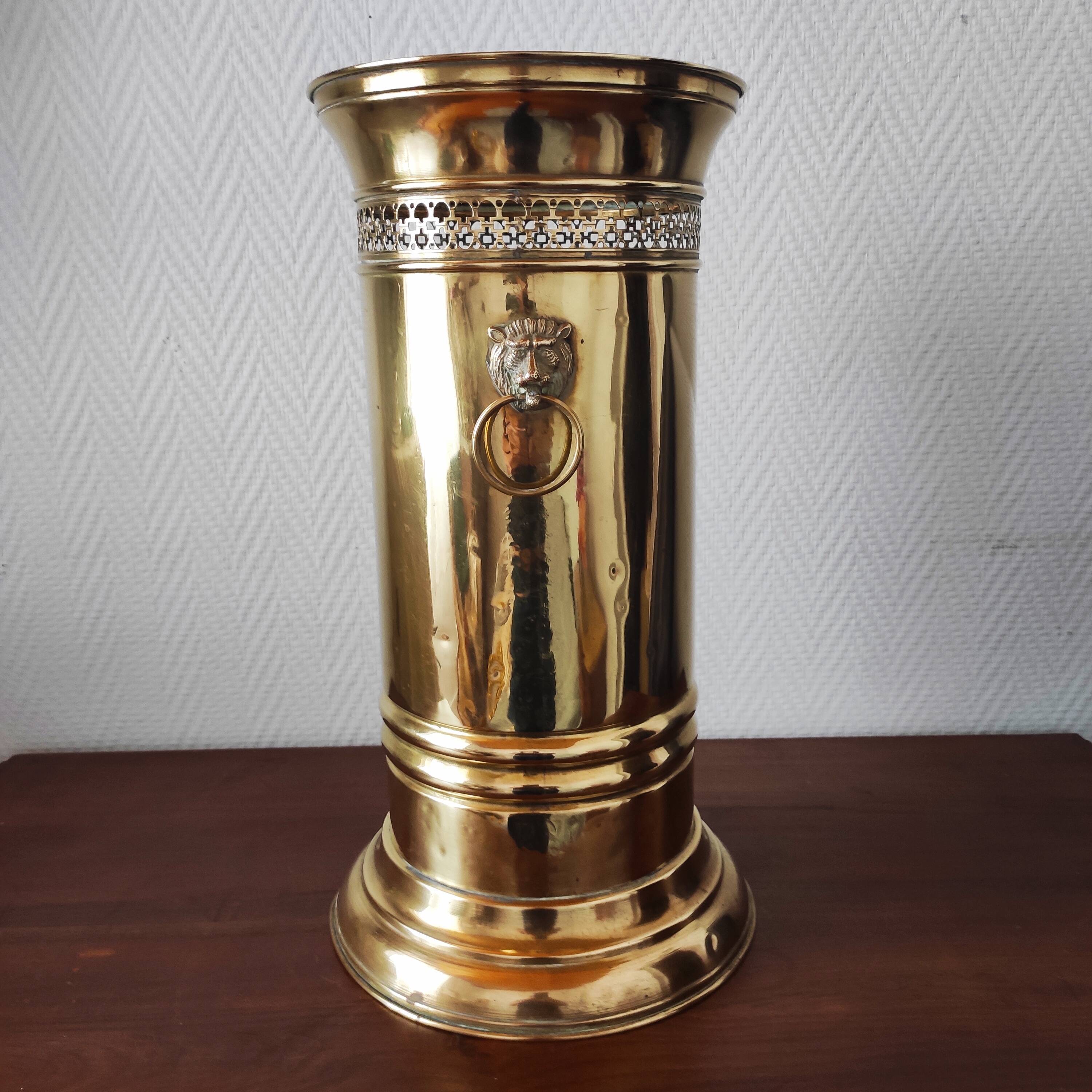 Vintage brass umbrella stand with lion decoration.