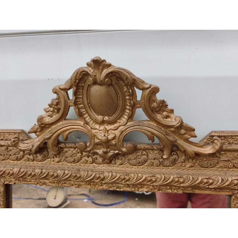 19th-century mirror in gilded wood and stucco.
