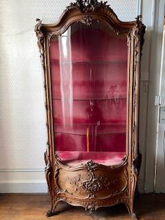 Large wooden display cabinet in Louis XV/rococo style with a strongly curved front.