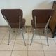 Two brown faux leather chairs.