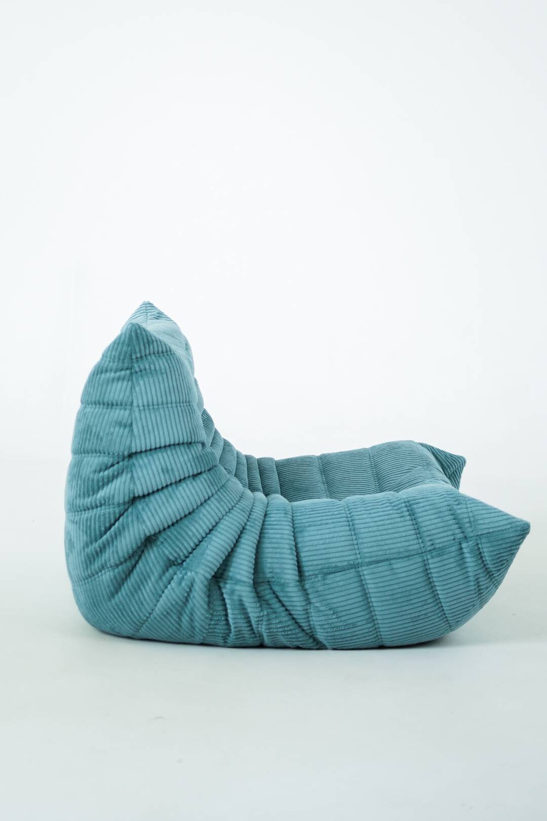 Ensemble de fauteuil et pouf Togo en velours côtelé bleu clair.
