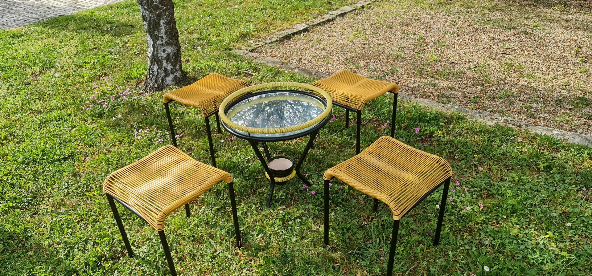 Salon de jardin comprenant table basse ronde en scoubidou et 4 tabourets assortis