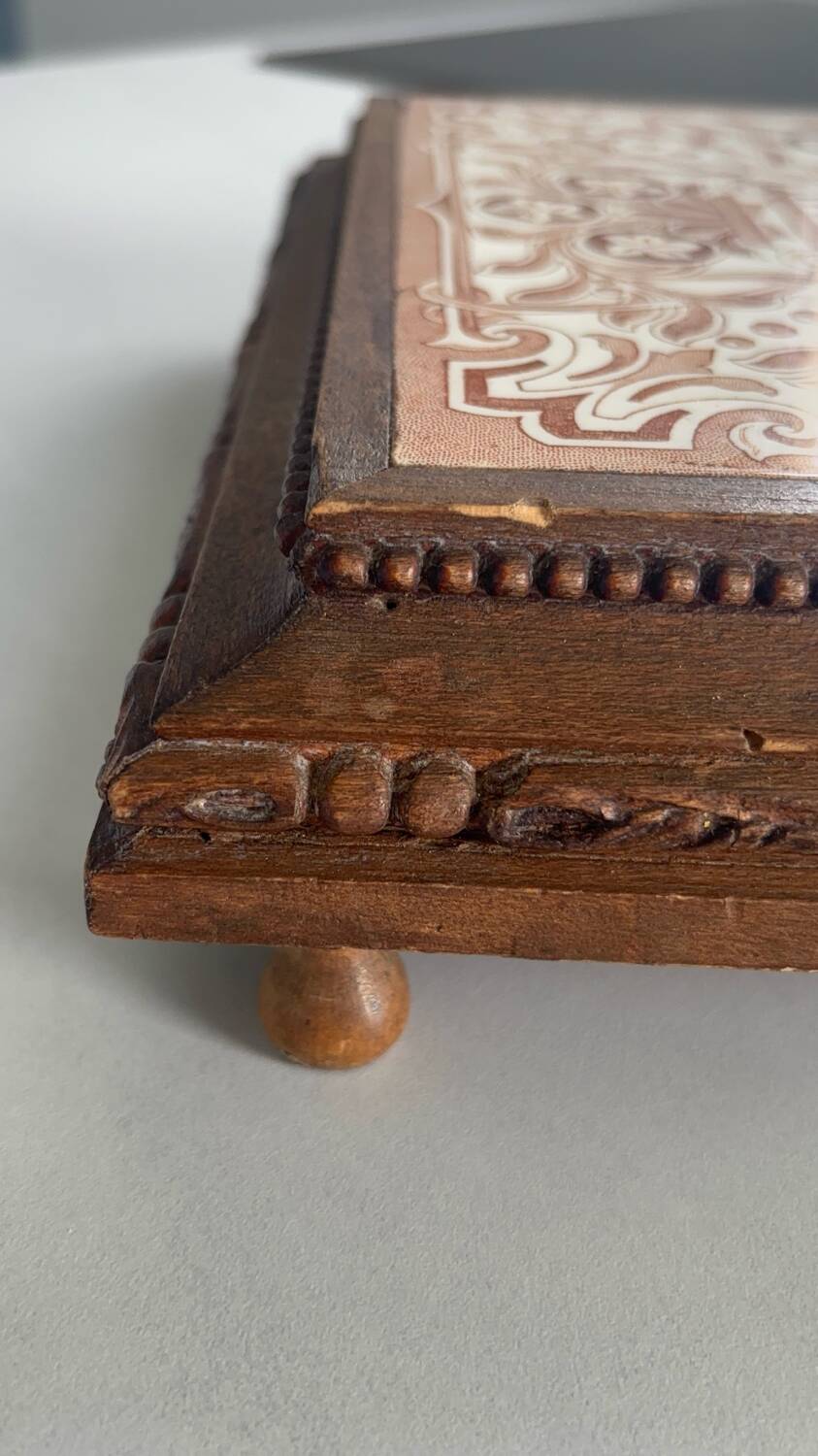 Vintage wooden and antique earthenware trivet, brown tile design