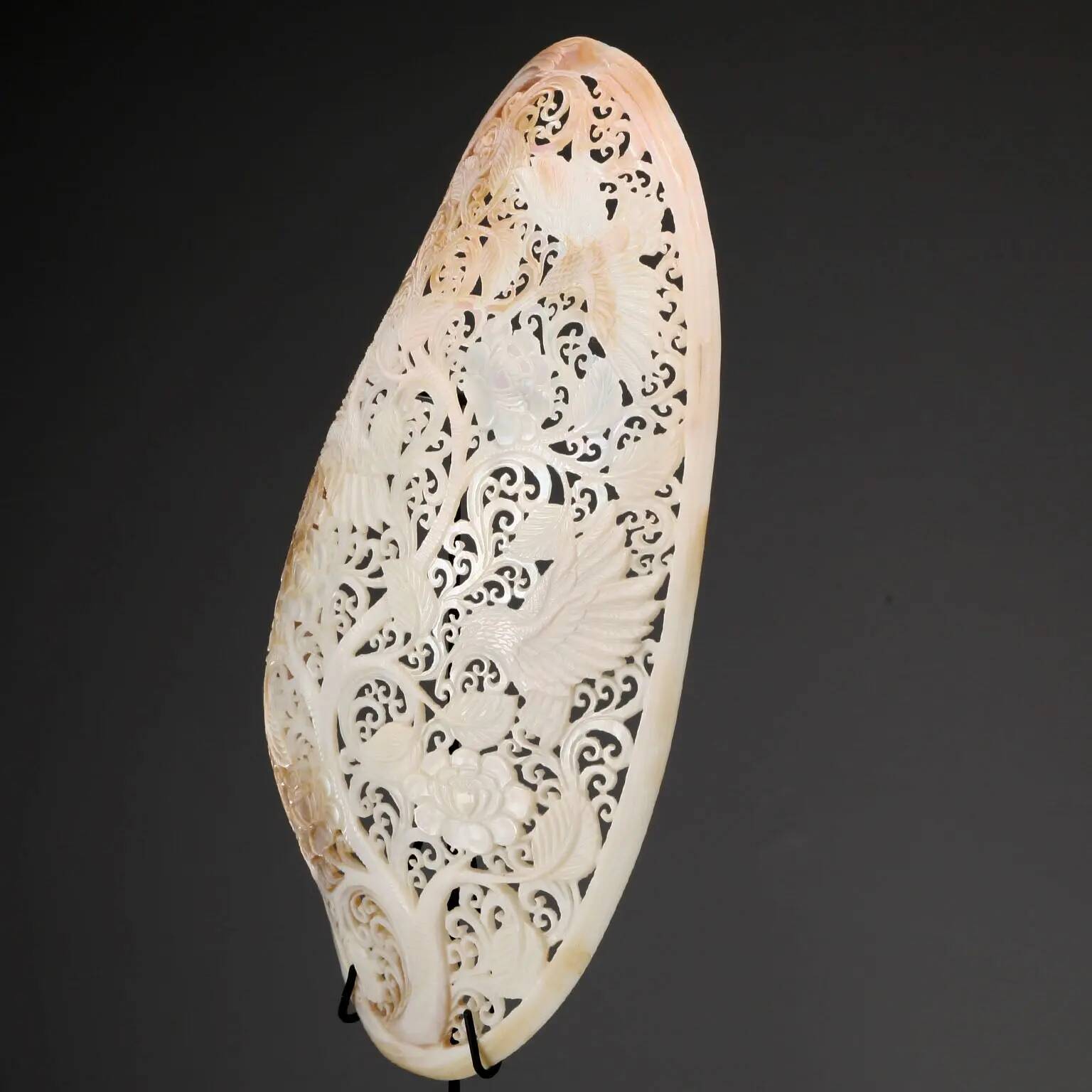 Perforated shell hand-decorated on a wooden base