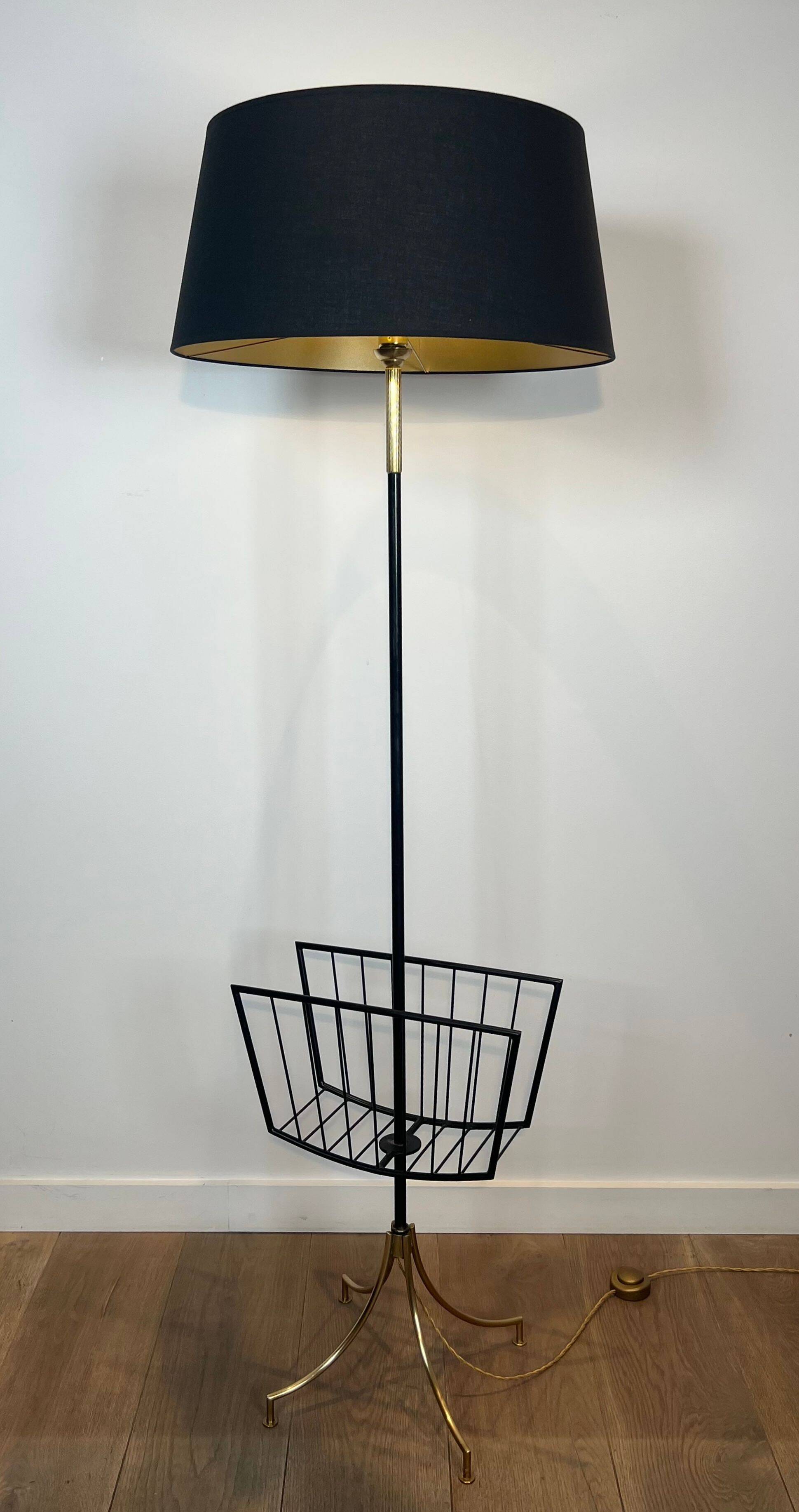Designer floor lamp in black lacquered metal and brass, incorporating a magazine rack
