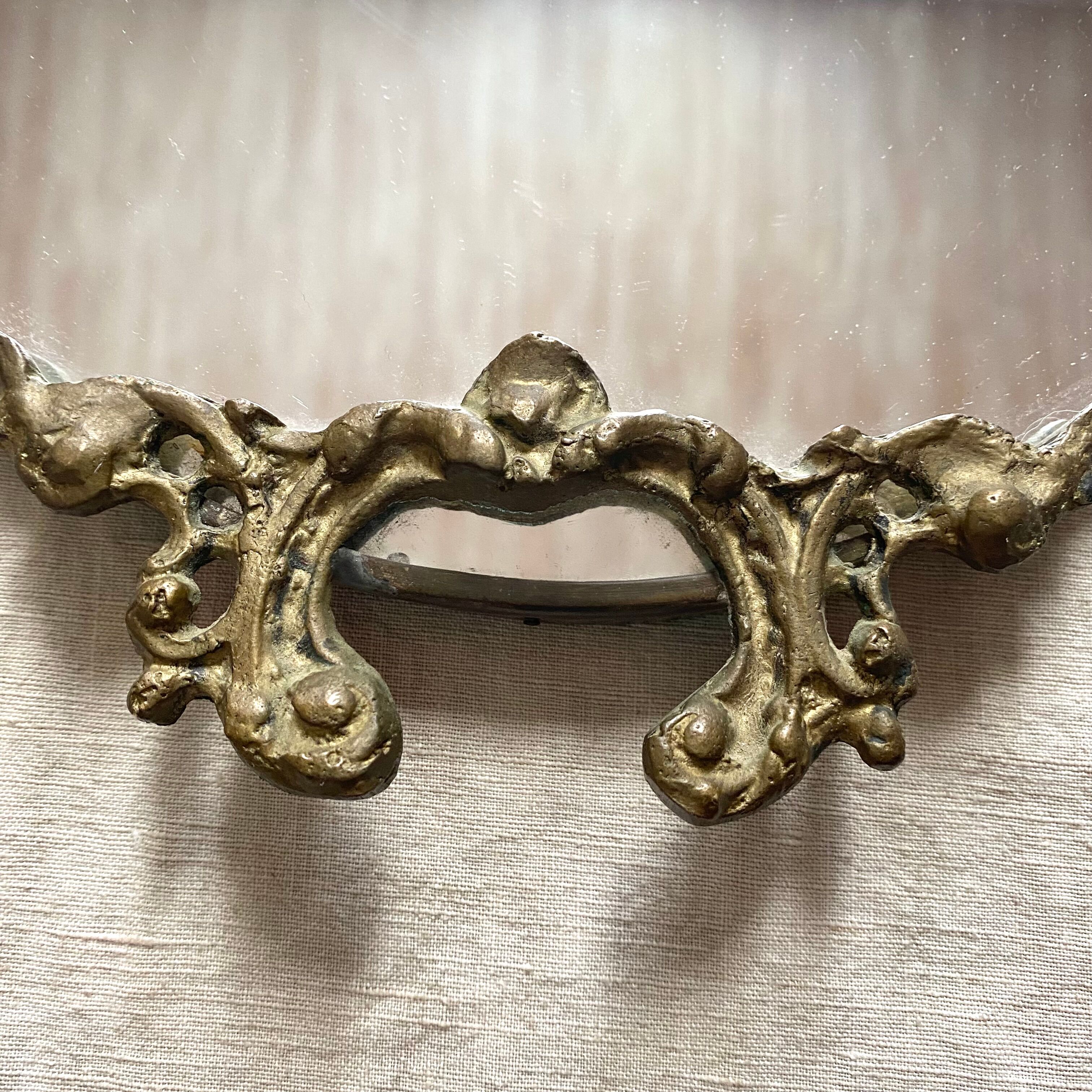 Antique oval brass crest mirror, 41x26 cm