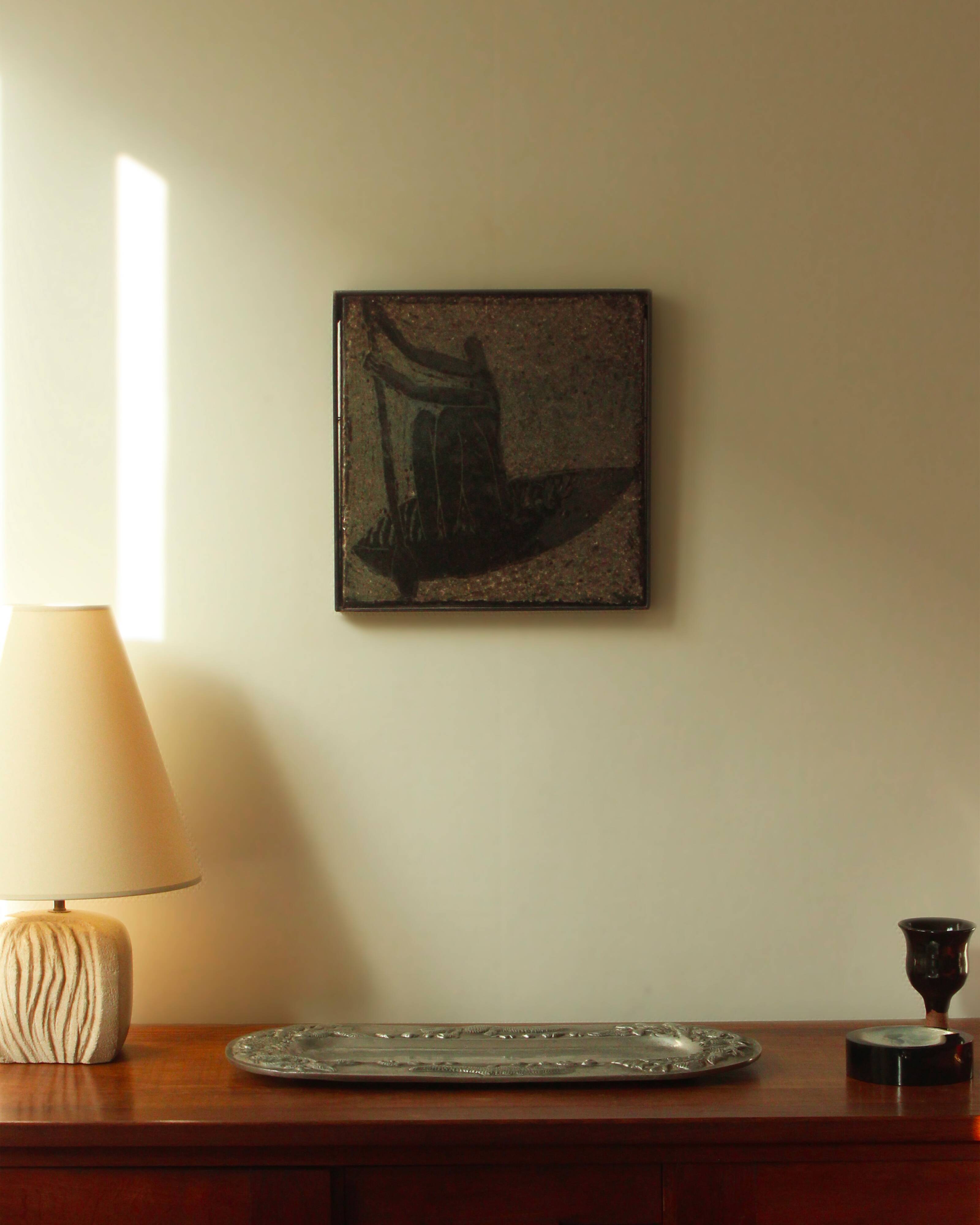 Glazed chamotte clay plaque in grey-green and black, decorated with a rower.