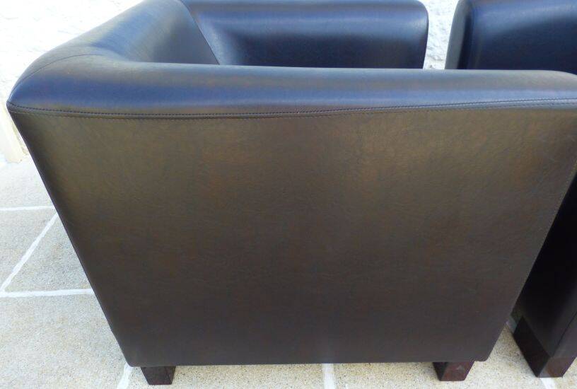 2 club armchairs with a chocolate faux leather seat and backrest and wooden legs.