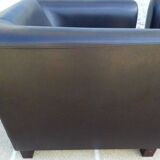 2 club armchairs with a chocolate faux leather seat and backrest and wooden legs.