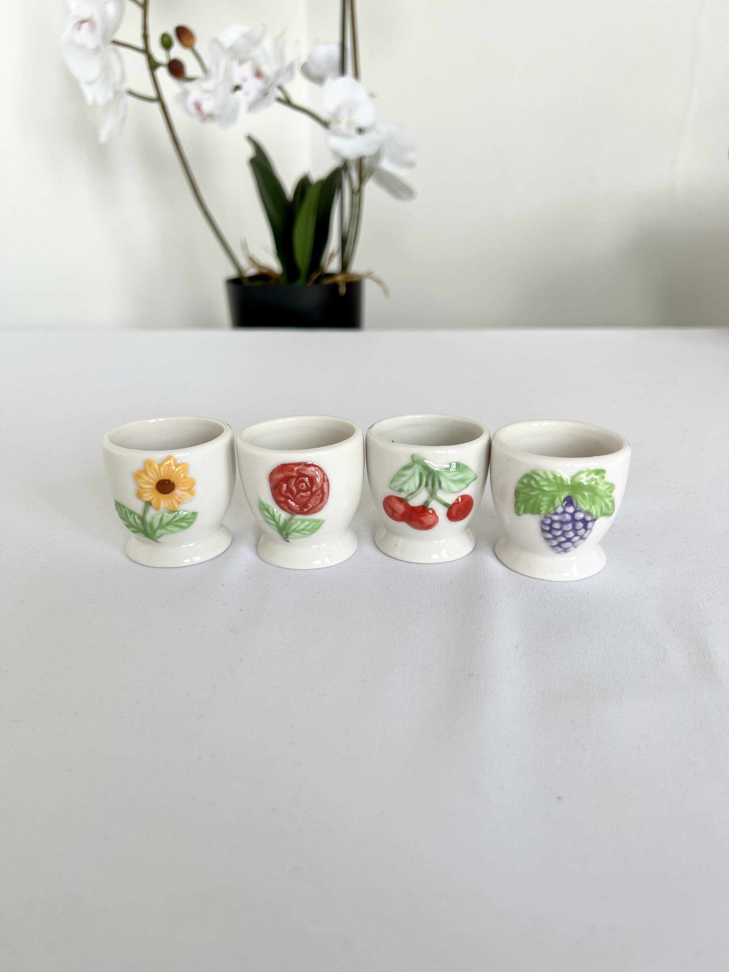 Quatre coquetiers vintage barbotine motifs fleurs et fruits porcelaine blanche