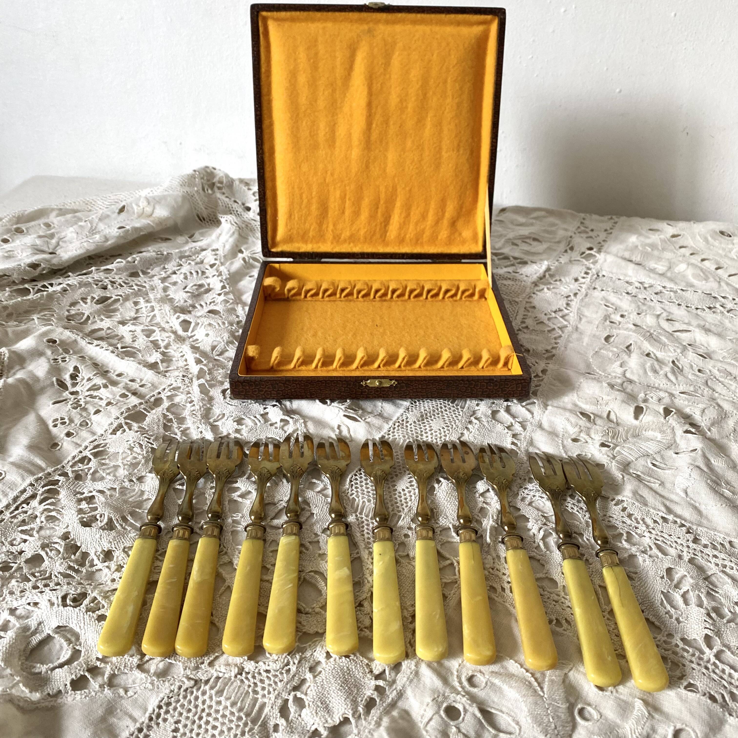 Antique dessert forks in brass and bakelite