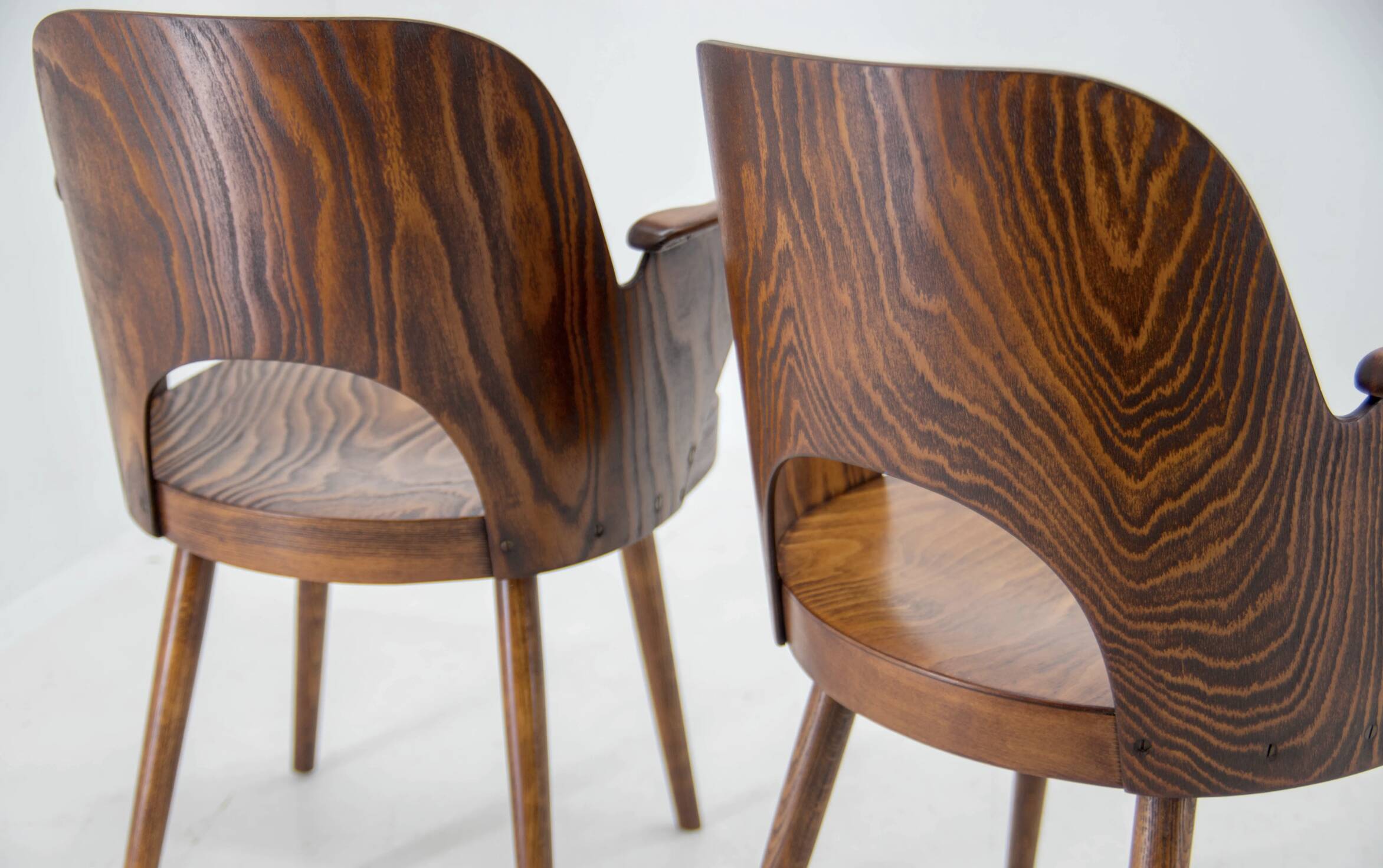 Pair of curved wooden shell armchairs in the style of Oswald Haerdtl.