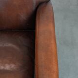 Ensemble de 2 fauteuils en peau de mouton au design art déco avec des couleurs chaudes.