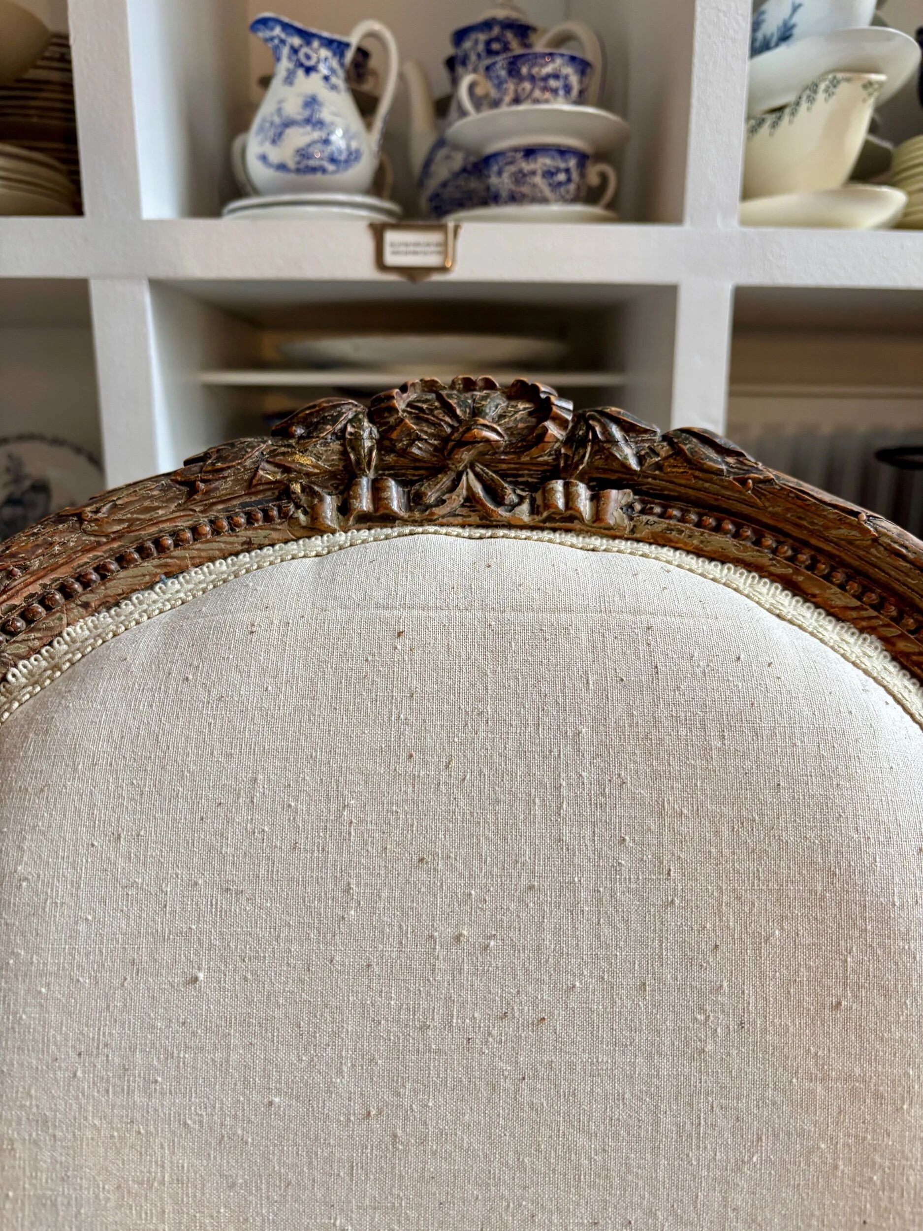 Medallion back chair in moulded wood and beige fabric.