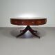Table basse / table tambour victorienne « Heldense » en acajou avec plateau en cuir sur roulettes en laiton. Années 1980