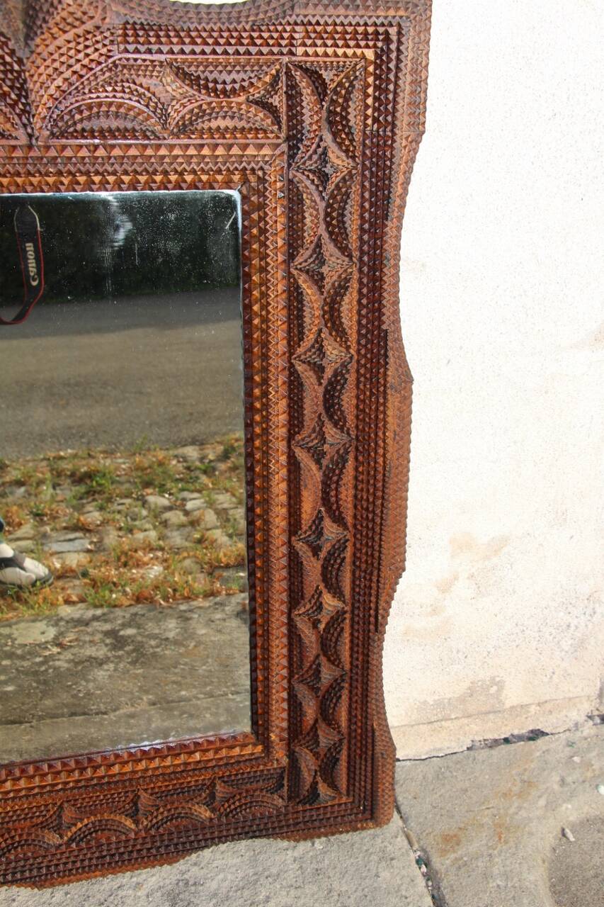 Tramp Art mirror from the 19th century in hand-carved wood.