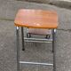Folding stool in formica with a wood effect.
