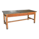 Large industrial workshop table in brown wood, wide top and sturdy vintage legs.