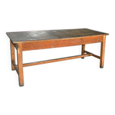 Grande table d'atelier industrielle en bois marron, plateau large et piétement robuste vintage