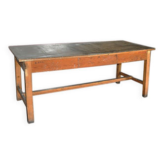 Large industrial workshop table in brown wood, wide top and sturdy vintage legs.