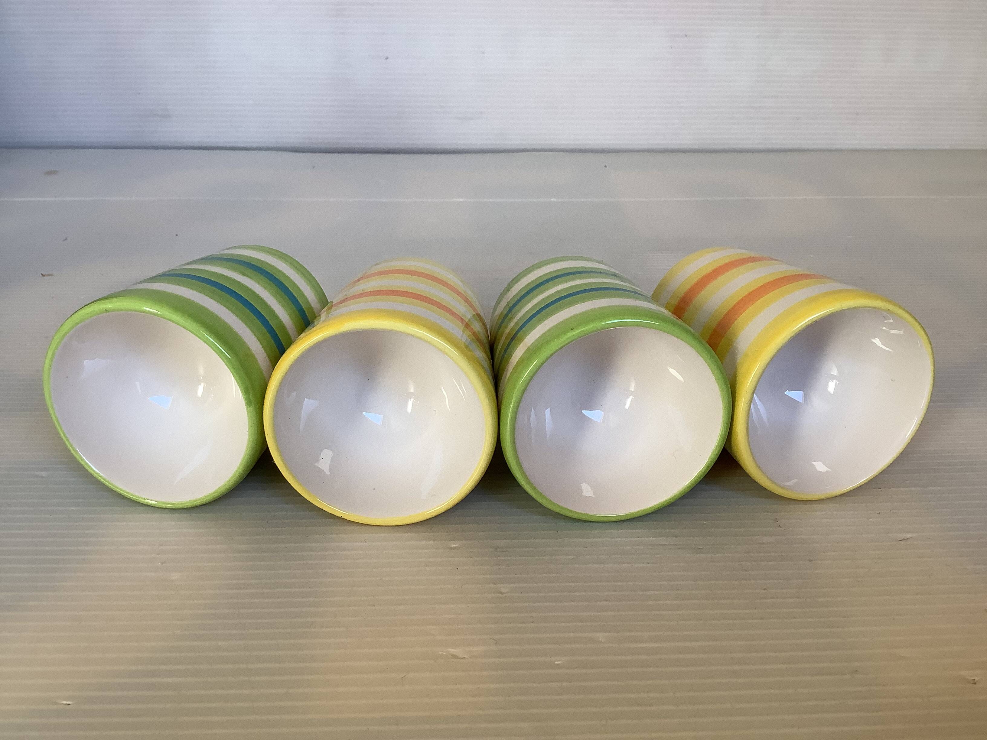 Four striped egg cups in yellow and green.