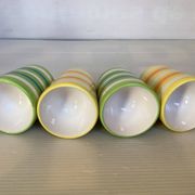 Four striped egg cups in yellow and green.