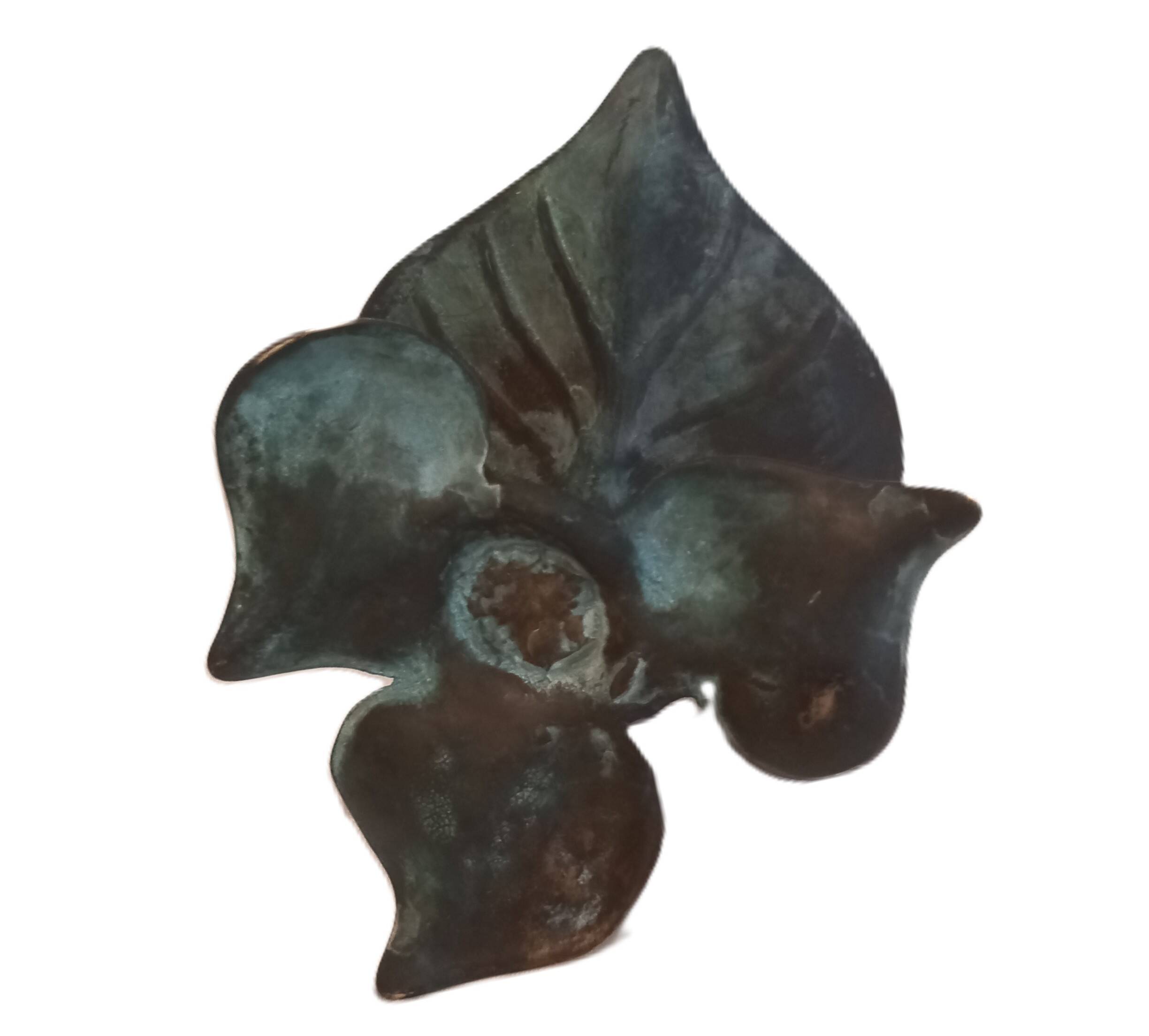 Patinated green brass candlestick with foliage decoration.