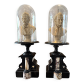 Pair of busts of Bellini and Puccini under a glass dome.