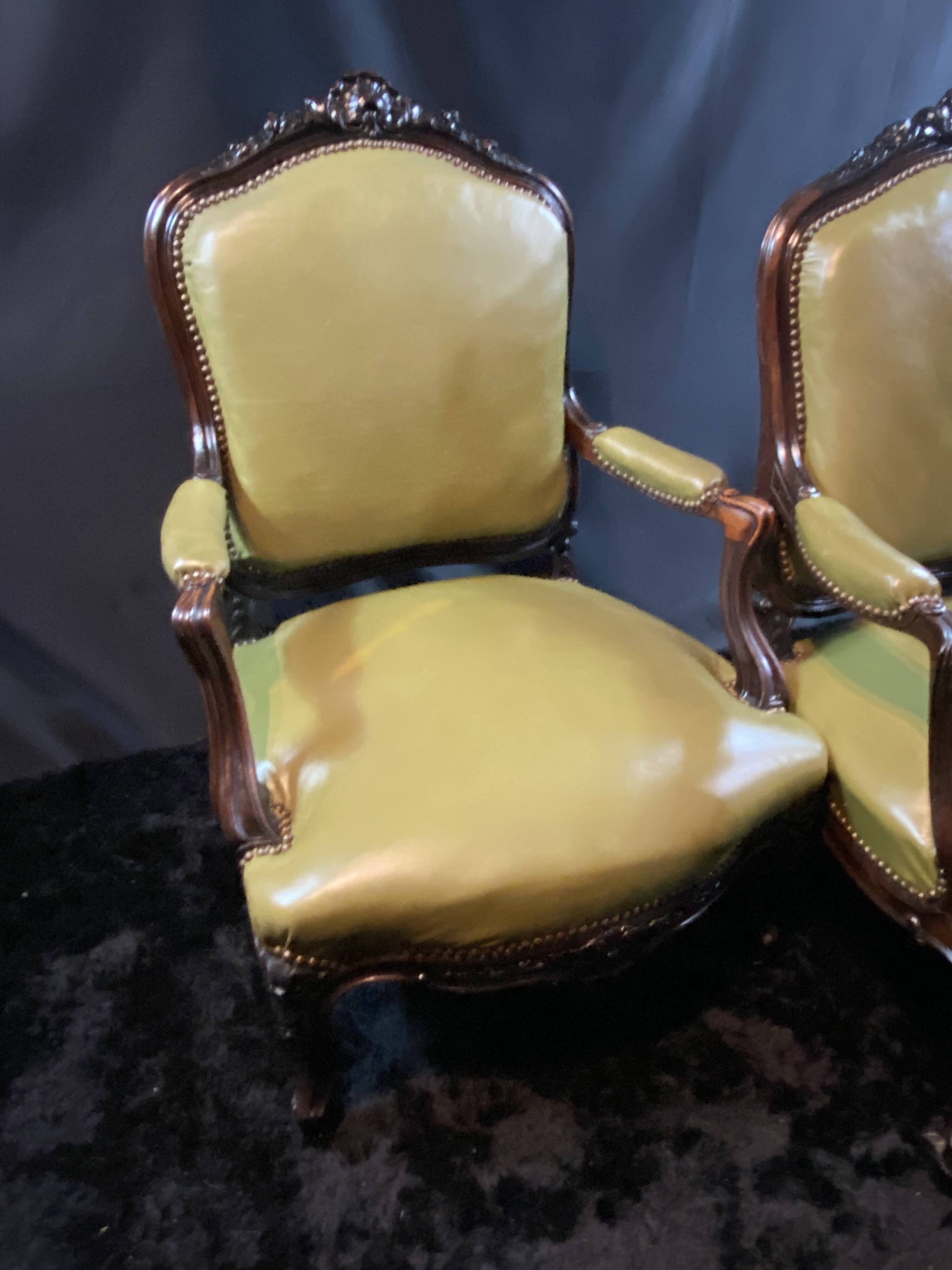 Paire de larges fauteuils XIXe en cuir vert de style Louis XV