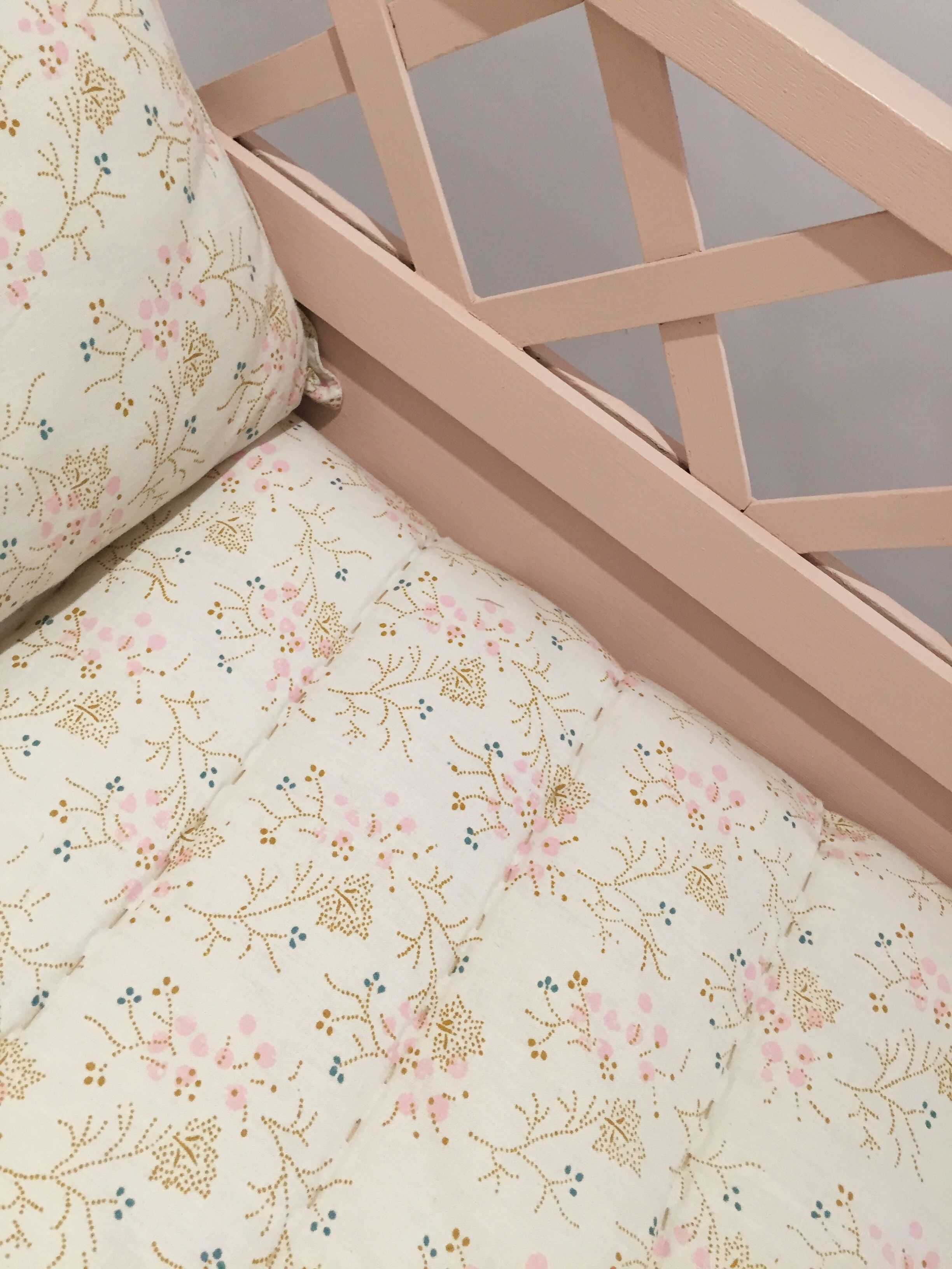 Vintage wooden baby bed in old pink
