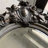 Beveled oval mirror in wood and stucco
