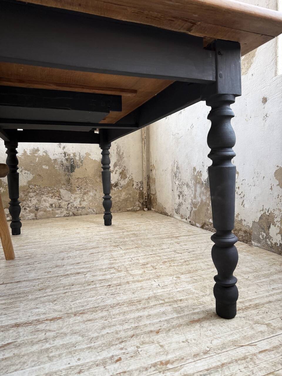 Oak farmhouse table with turned black legs.