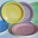Seven pastel-colored plates mixed with vintage earthenware