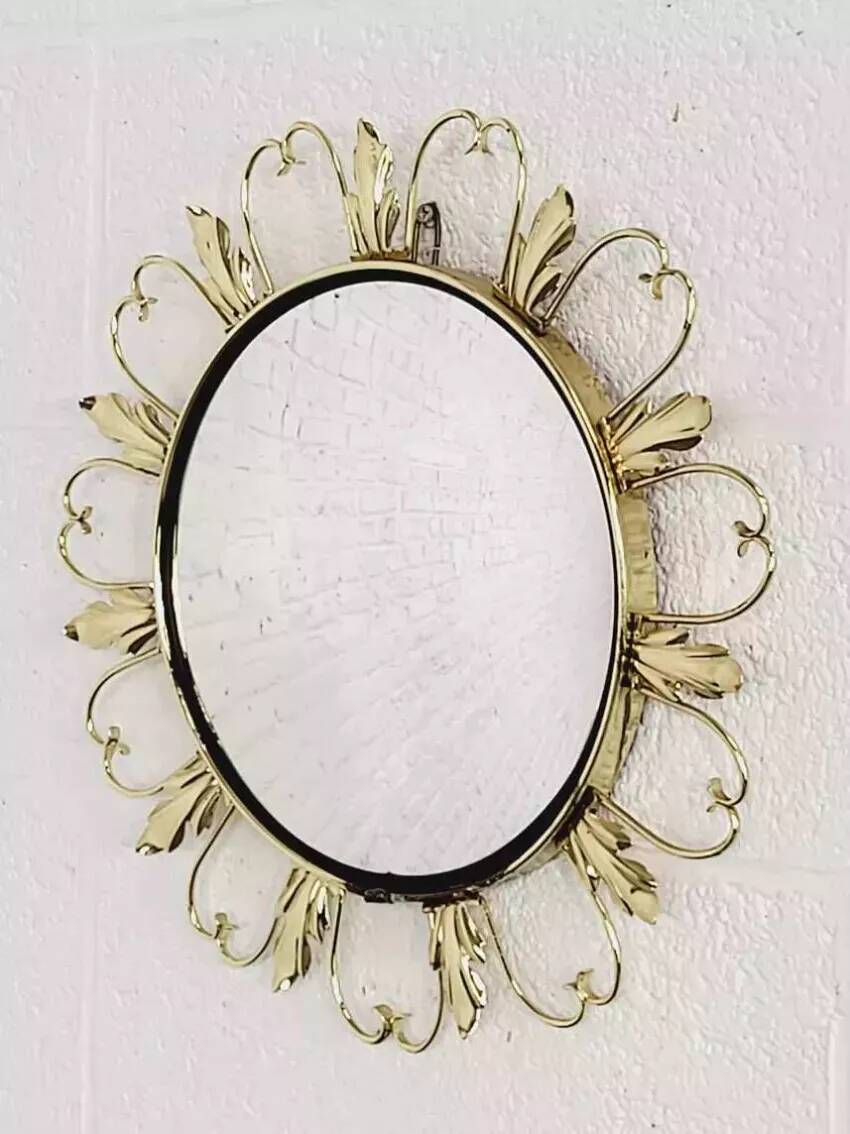 Round mirror on a brass frame with scrolls