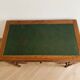 Antique wooden desk with a sloped top and green writing pad.