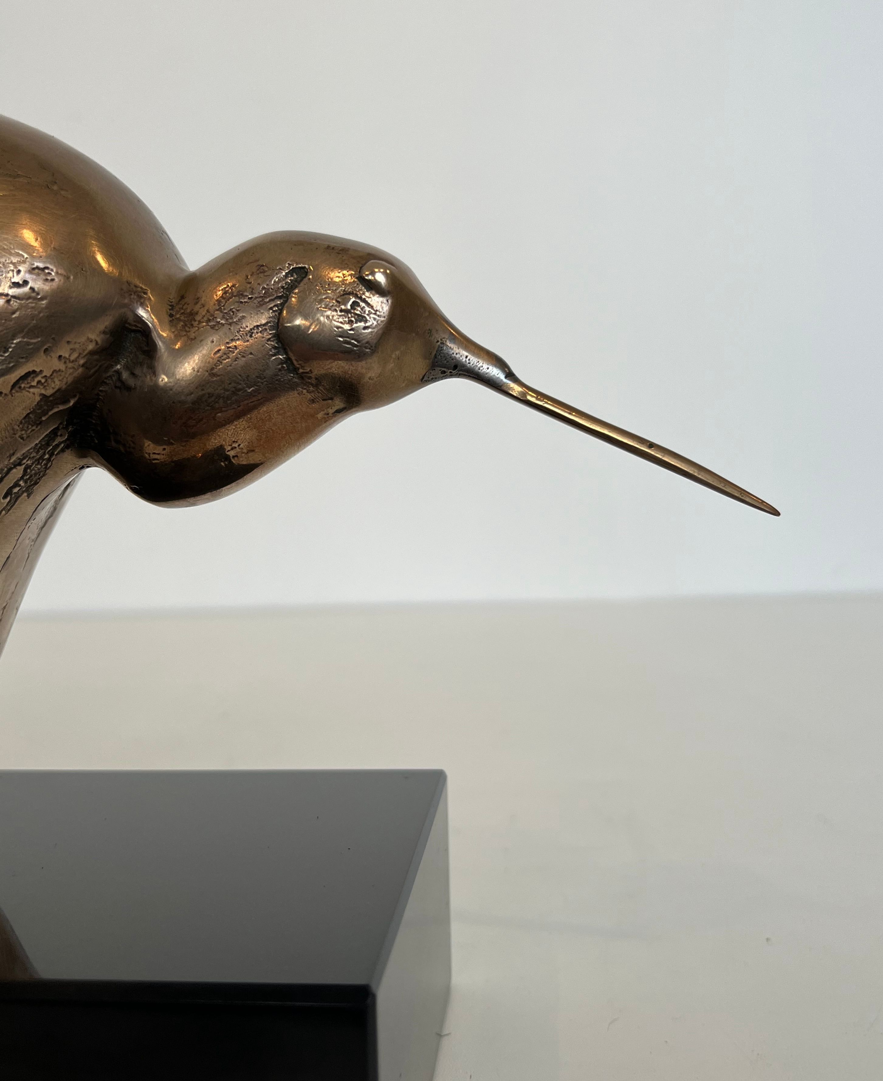 Bronze sculpture representing a stylised bird on a black marble base, signed and numbered.
