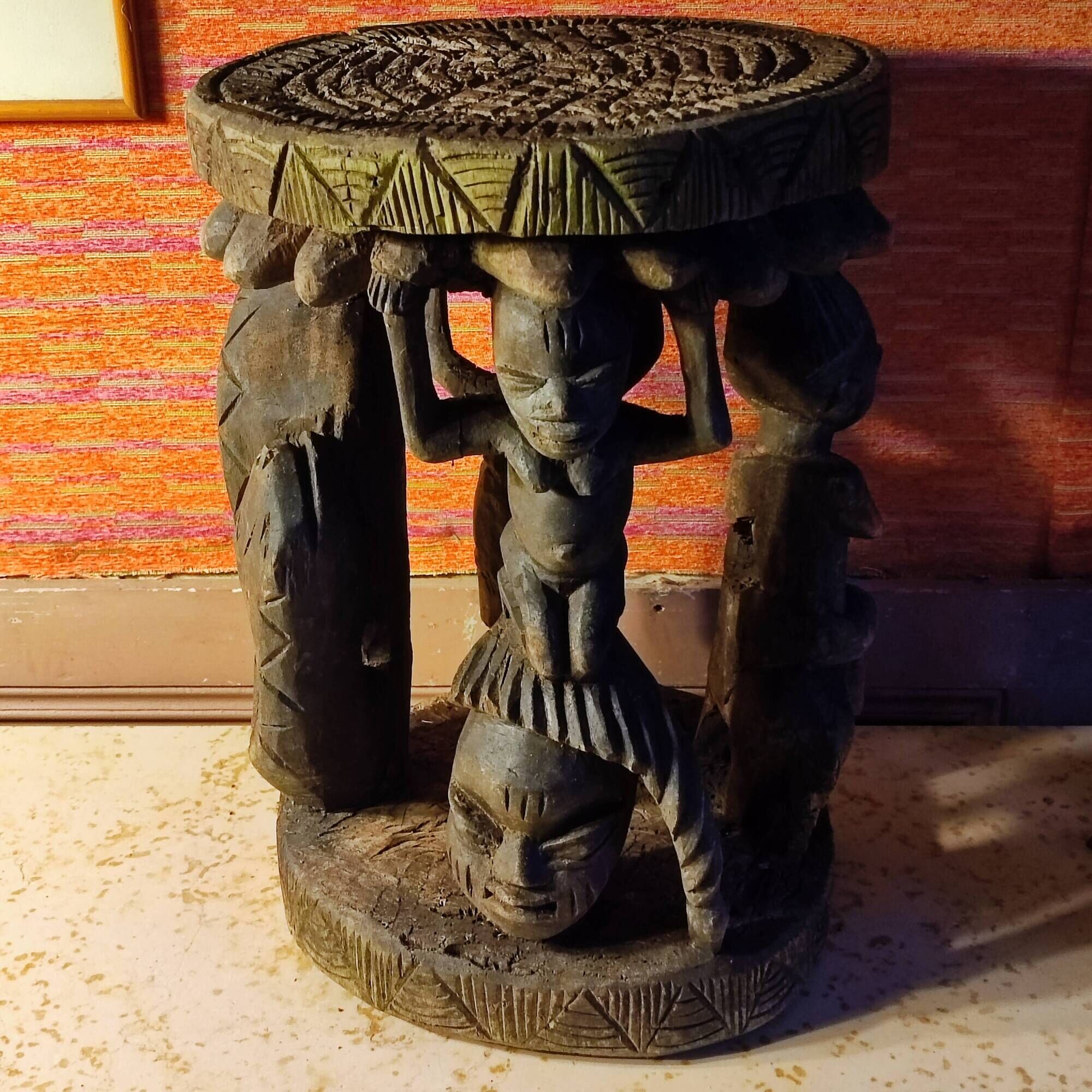 African wooden stool carved in the shapes of characters