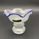 Eisch glass footed cup with pearlescent finish, blue rim.