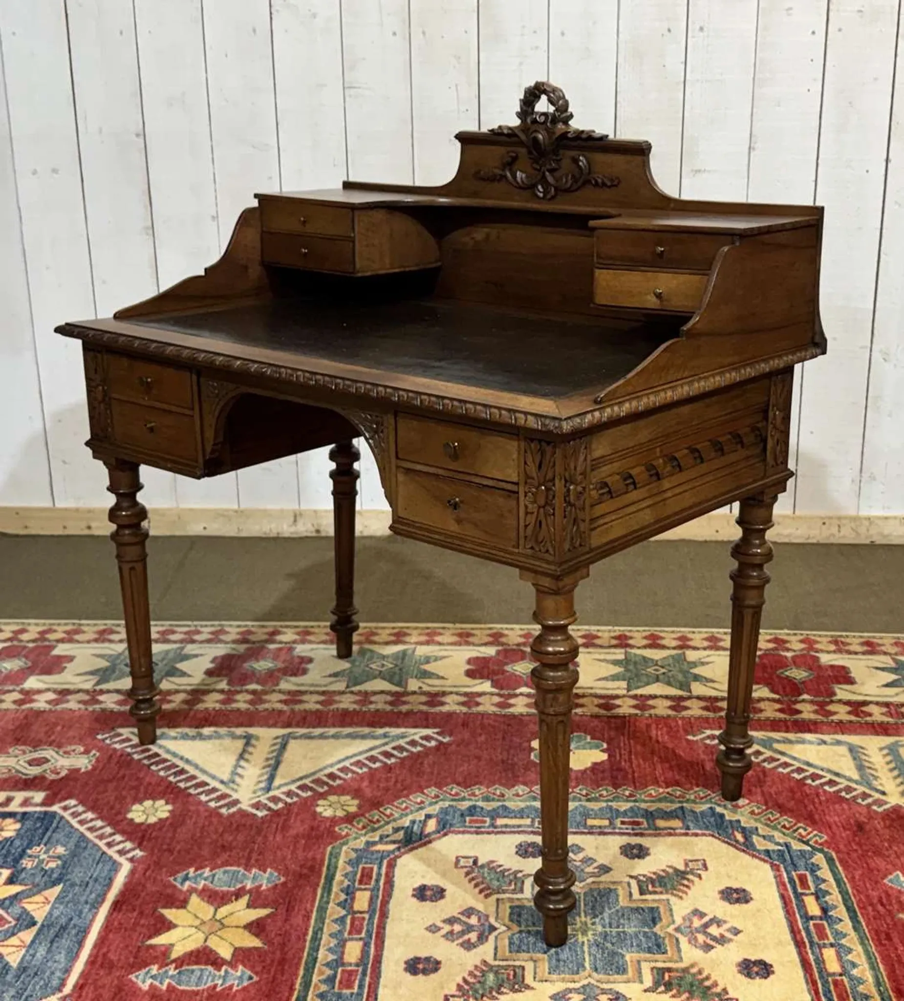 Louis XVI style desk from the late 19th century in walnut with a leather top.