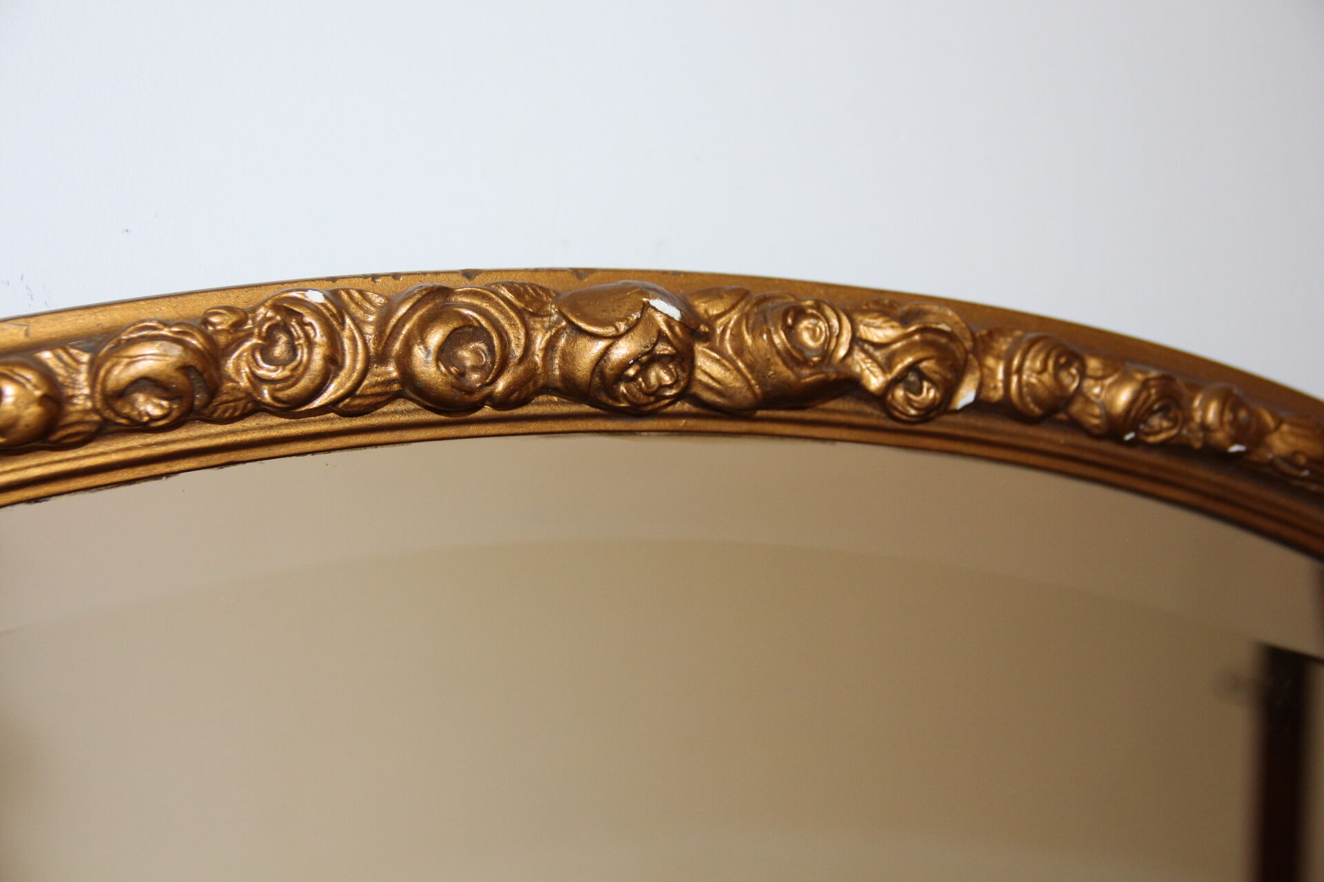 Beveled oval mirror in gilded wood