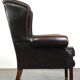 Chesterfield wing chair in dark brown leather with a luxurious appearance