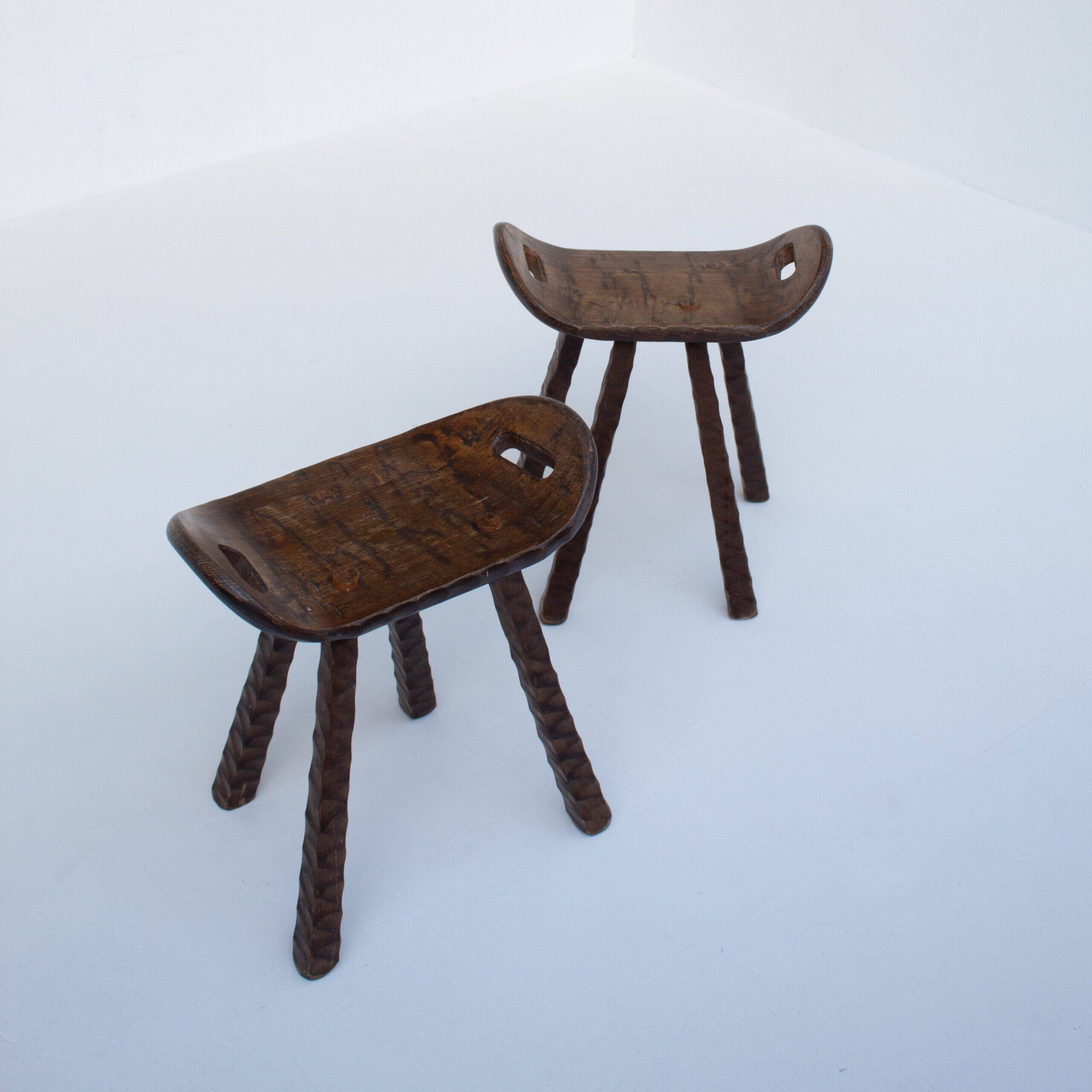 Ensemble de deux tabourets en bois sculptés à la main avec poignées.