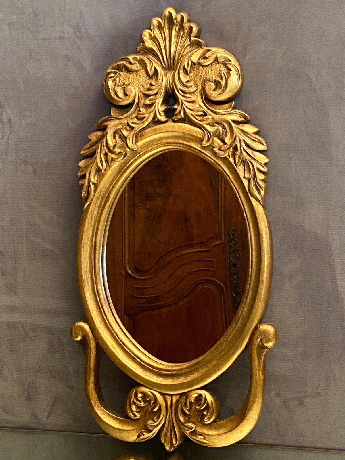 Oval view mirror in gilded wood with leafy decoration in Regency style