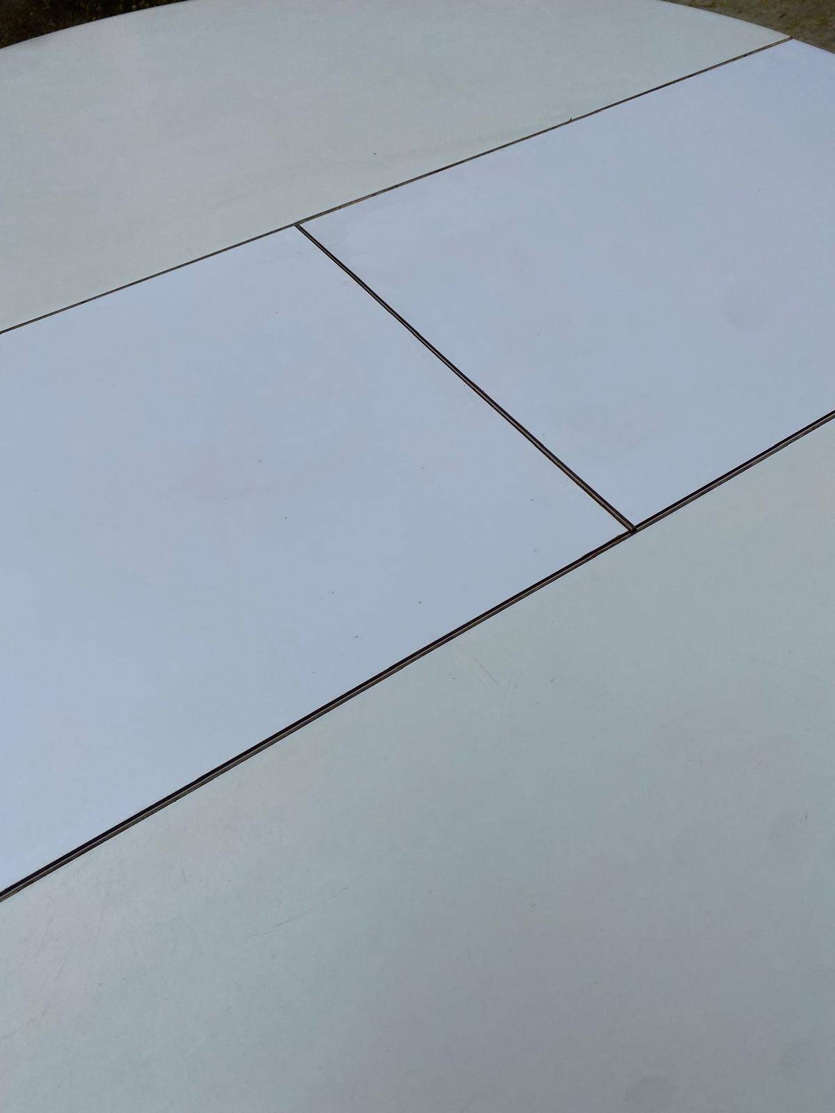 White dining table with a central tulip base, extendable to 100cm.