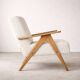 Mid-century modern armchair in solid wood and light beige fabric.
