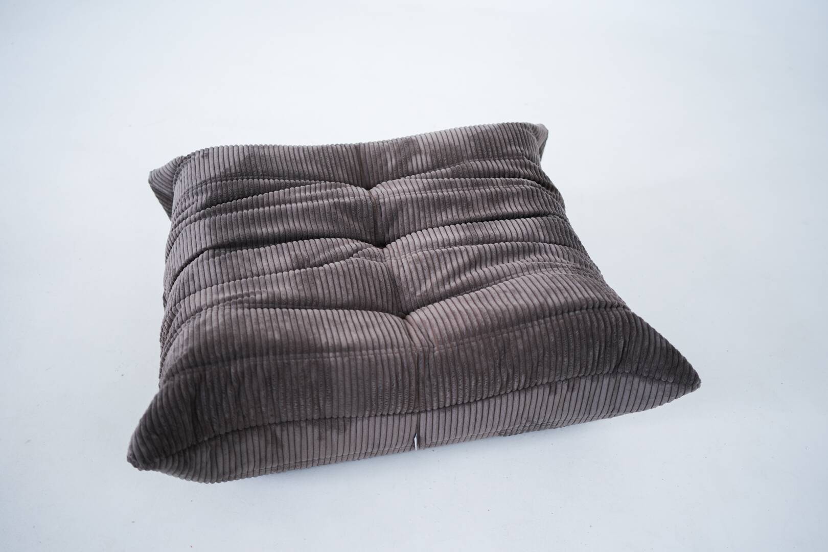 Ensemble de chaise et pouf Togo en velours côtelé marron.